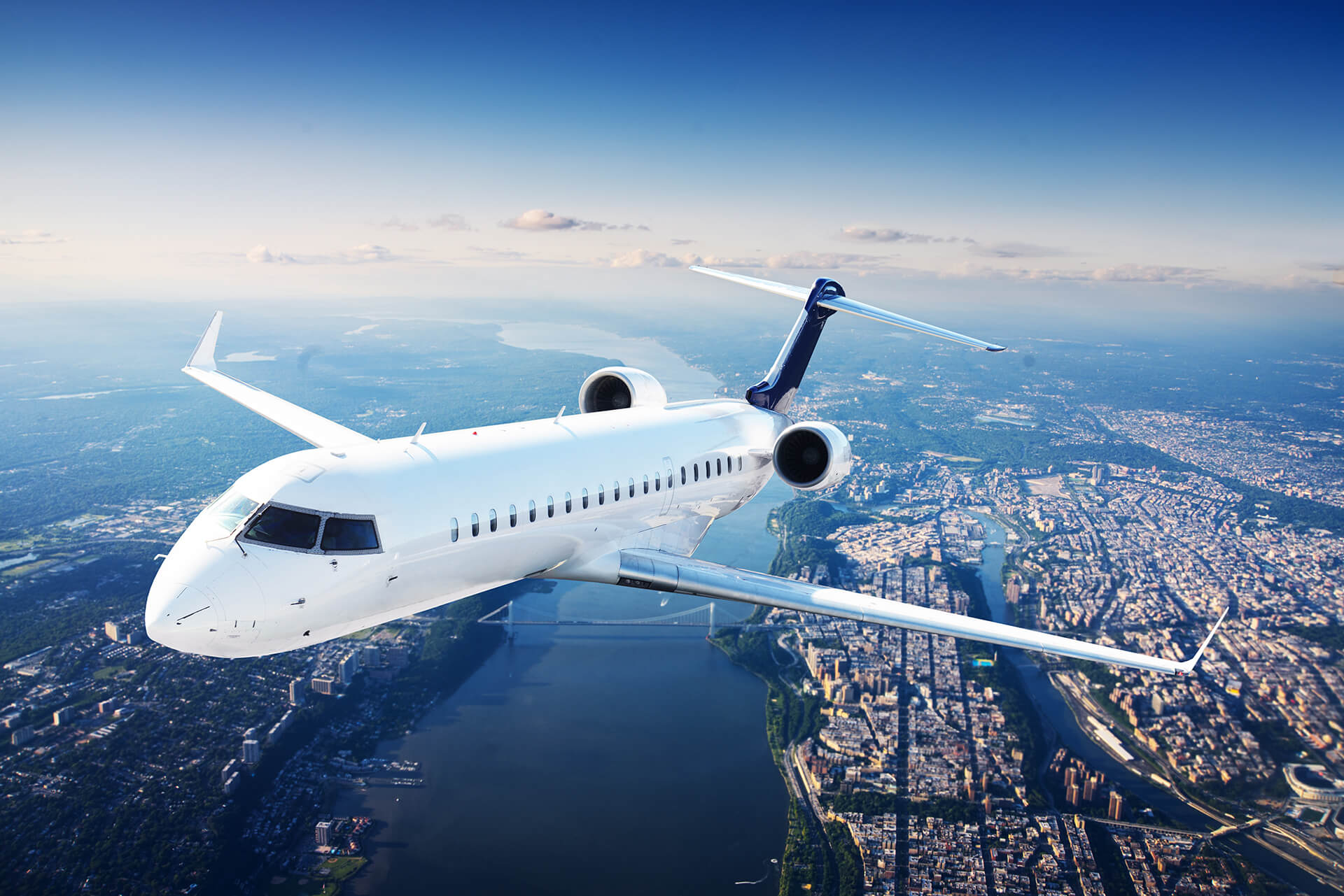 Aerial View of an airplane flying over a city with a river.